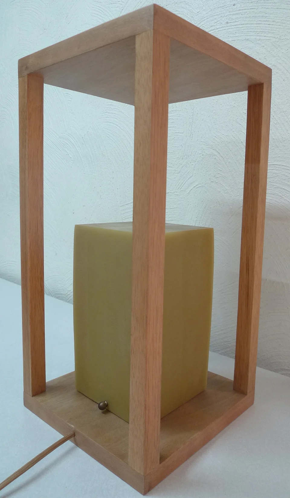 Amanecer — the resin cube resting low in the frame, like a rising sun