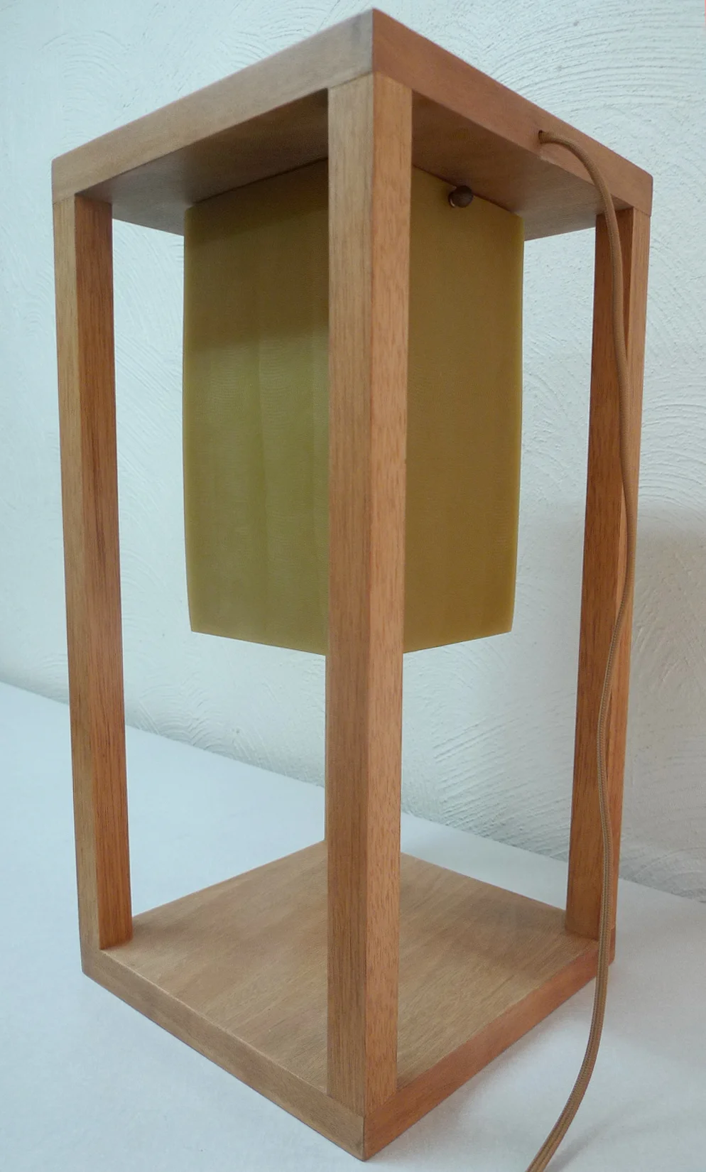 Atardecer — the resin cube lifted high in the frame, like a setting sun