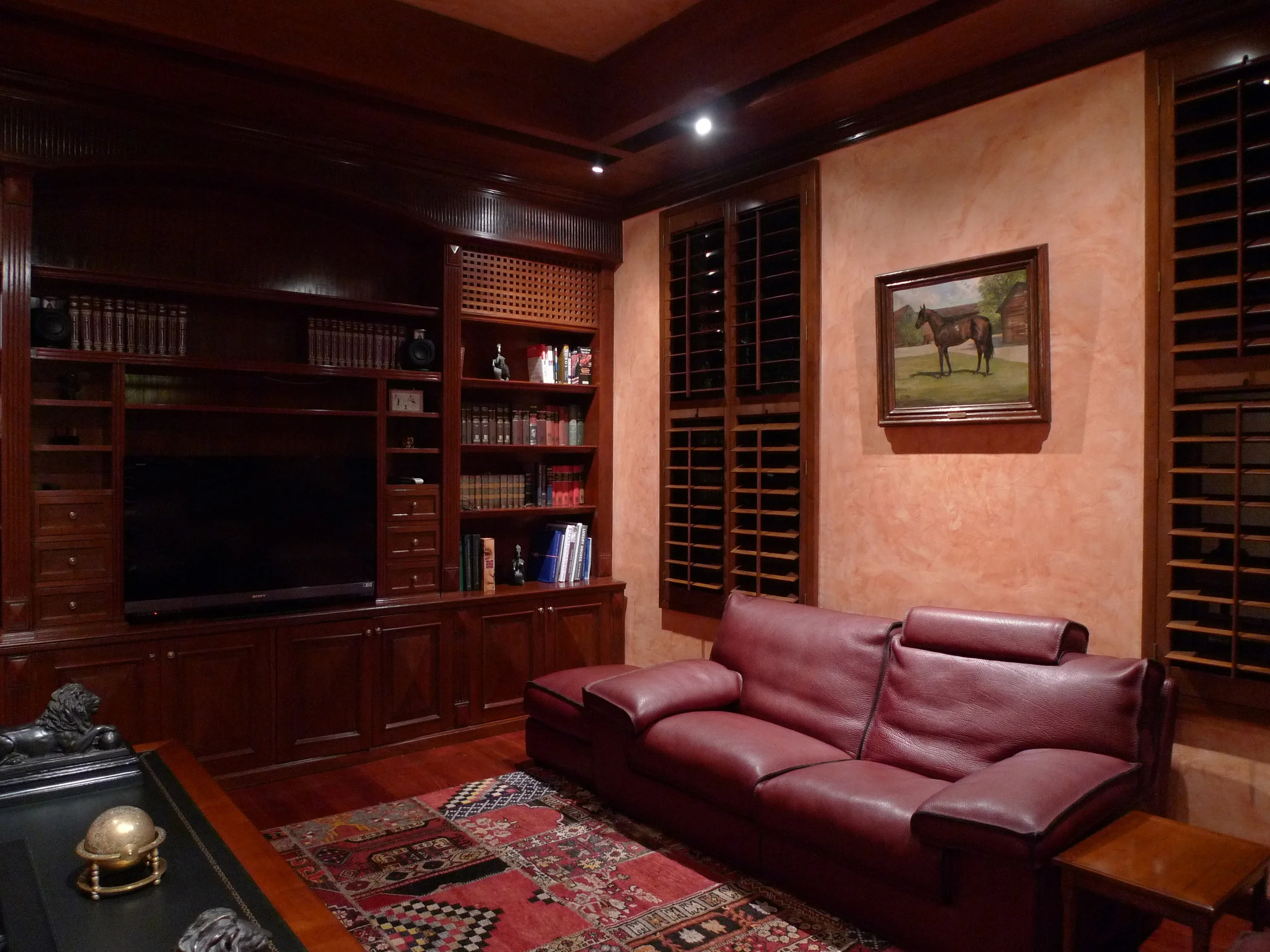 B Residence — wood-panelled den lit by warm recessed light