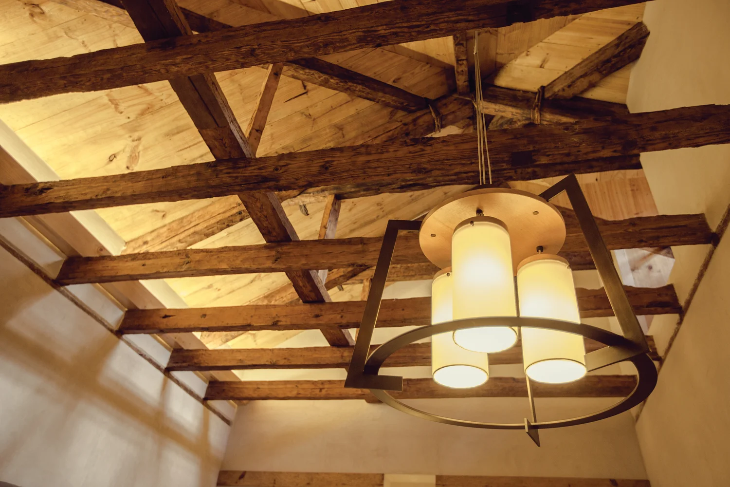 Custom pendant fixture against the original beamed ceiling