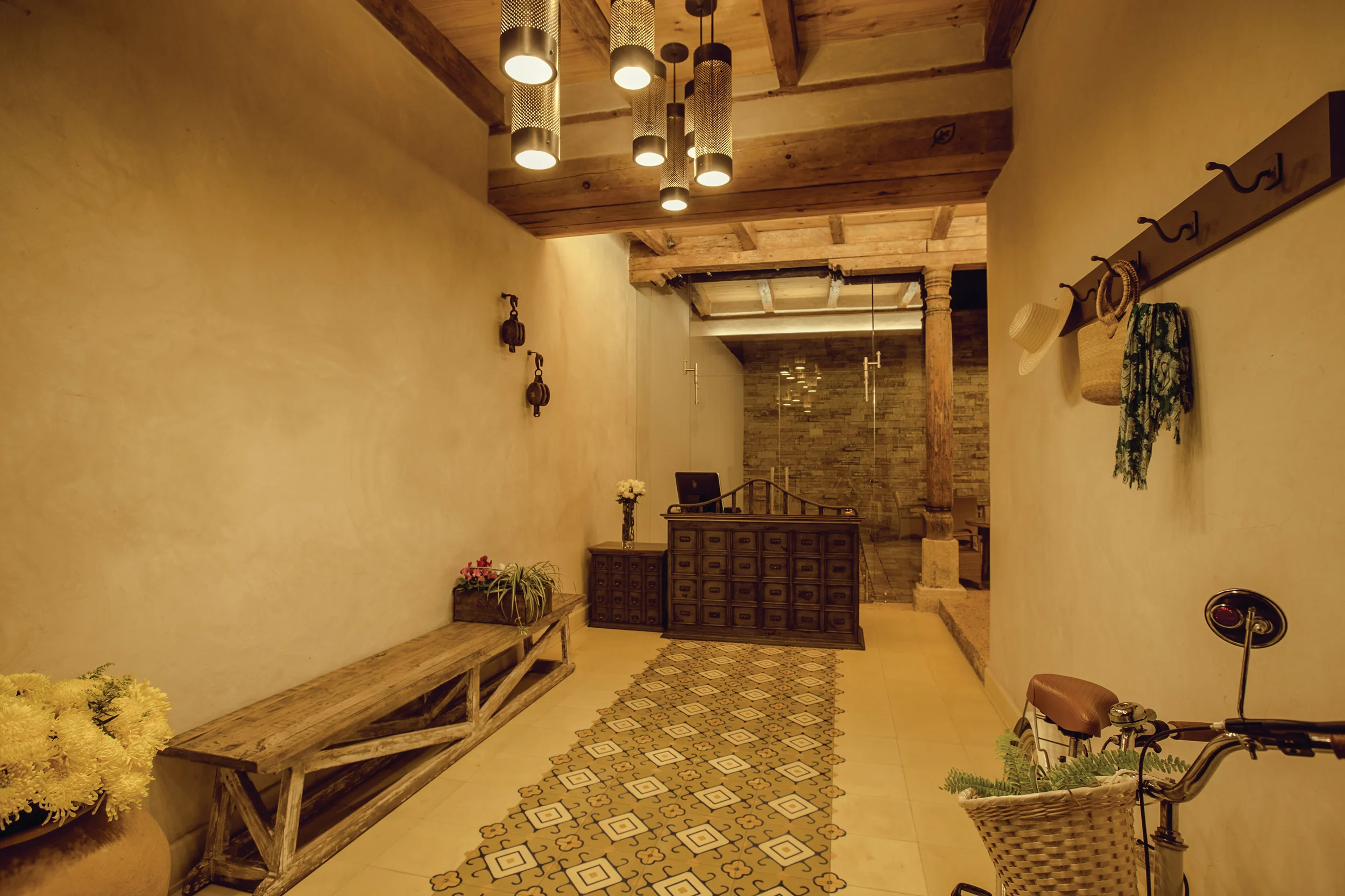 Casa Lum — entrance lobby with a cluster of custom pendant lanterns over a patterned tile runner