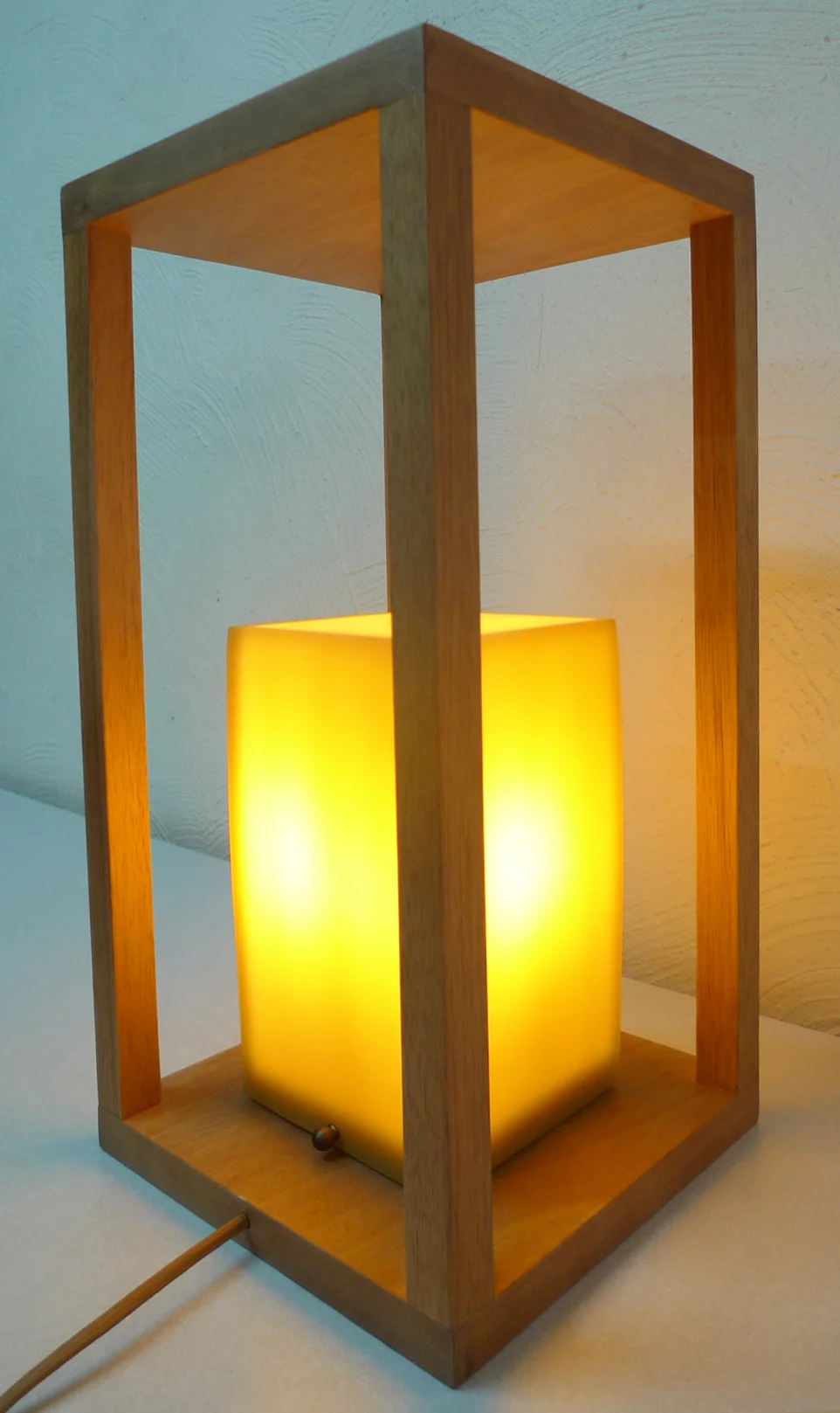 Custom LUM-family wood-and-glass lantern fixture glowing amber