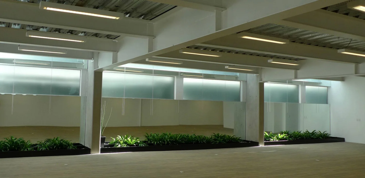 Open multipurpose floor with glazed partitions and planted thresholds