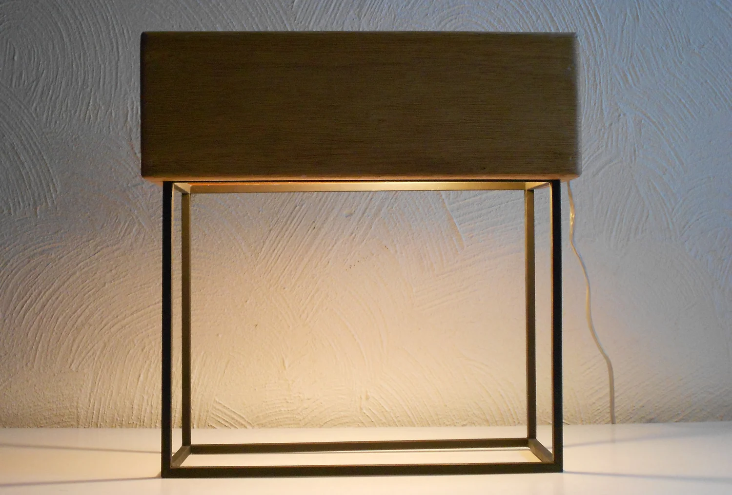 Totem — wooden shade glowing on its slim metal frame
