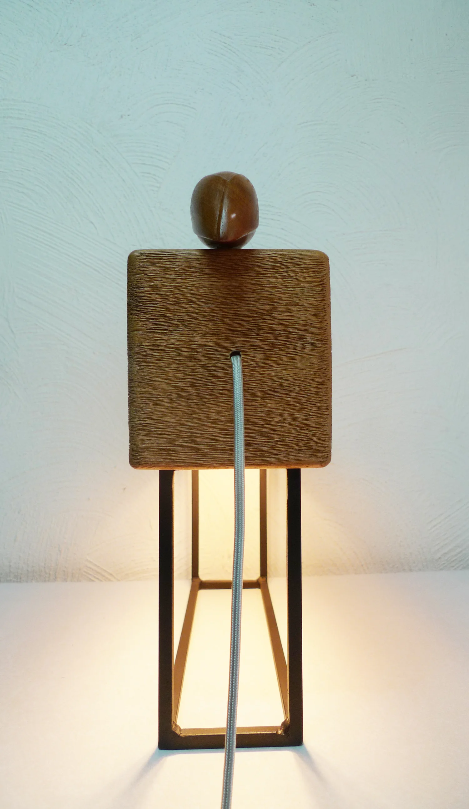 Totem — standing fixture topped with a carved wooden form